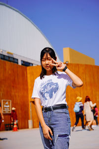 Young woman standing against the wall