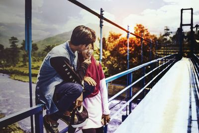 People on footbridge against sky