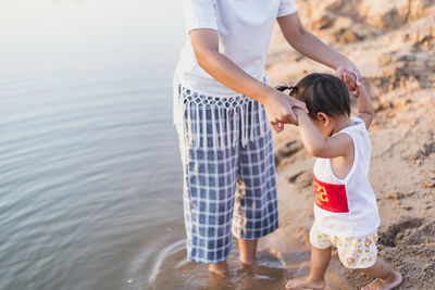 Mother and daughter walking on the beach.