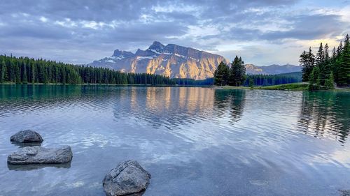 Scenic view of lake by mountains against sky