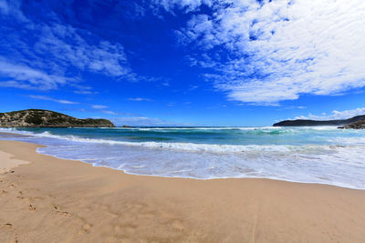 Scenic view of beach against blue sky