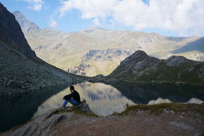 Man looking at lake against mountain range