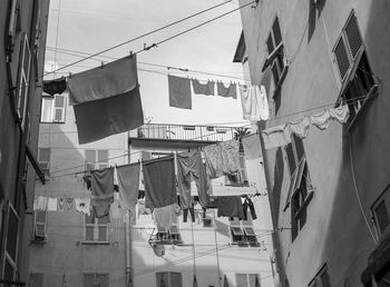 Low angle view of clothes hanging on buildings in city