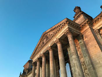 Low angle view of old building against blue sky