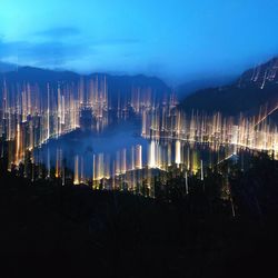 Illuminated cityscape against sky at night