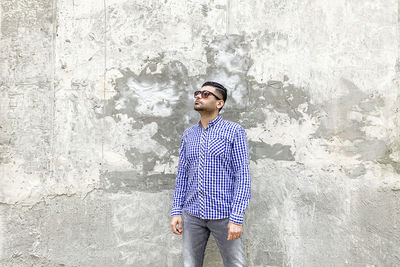 Full length of young man standing against wall