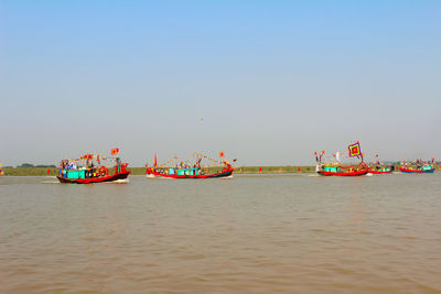 Boat sailing in sea against clear sky