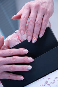 Pink wedding manicure for the bride, a girl in a wedding dress holds a bouquet