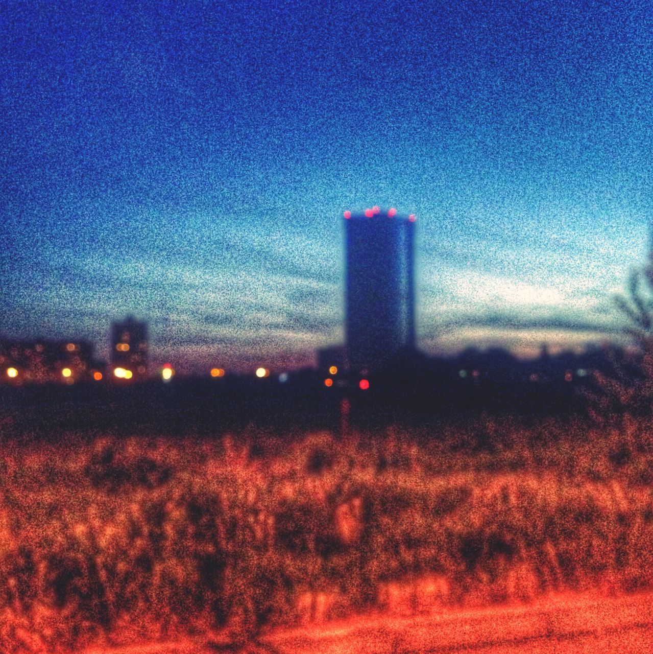 illuminated, building exterior, architecture, built structure, sky, night, dusk, blue, red, field, no people, copy space, outdoors, sunset, clear sky, landscape, city, smoke stack, tower, defocused