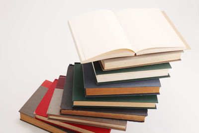 High angle view of stacked books against white background