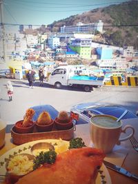 Close-up of breakfast served on table against buildings in city