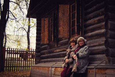 Portrait of smiling women sitting on cottage 