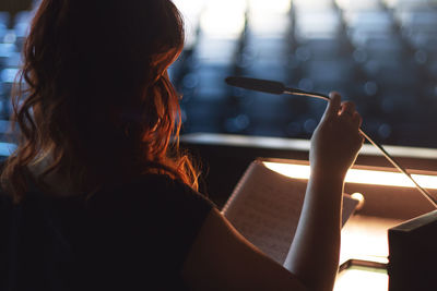 Rear view of woman reading book