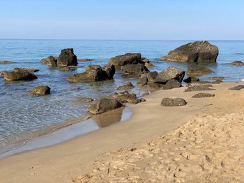 Rocks on beach against sky