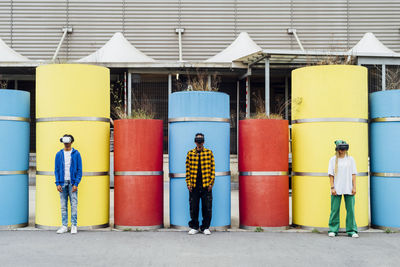 Multiracial friends wearing virtual reality simulator standing in front of pipes