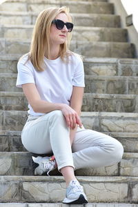 Portrait of young woman sitting on staircase