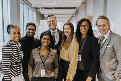 Portrait of smiling multiracial delegates standing in corridor