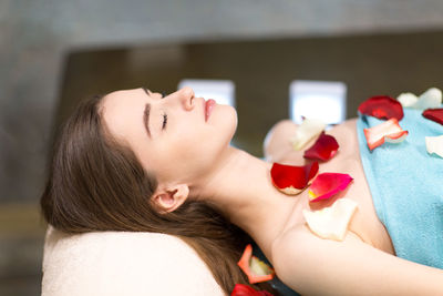 Woman on massage table covered with flower petals
