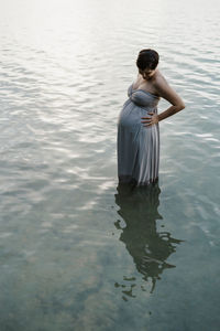  pregnant woman standing in lake