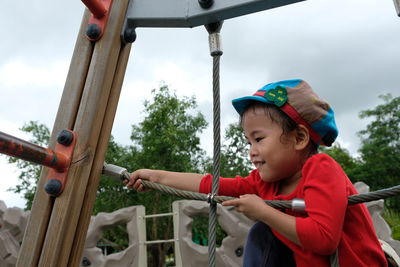 Girl climbing on rope in playground