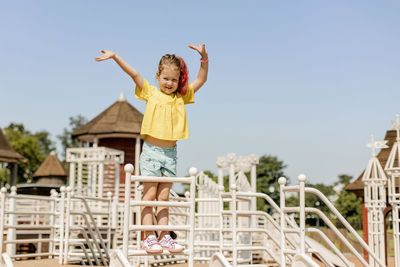 A charming little girl is having fun and playing on the playground. happy childhood, summer time