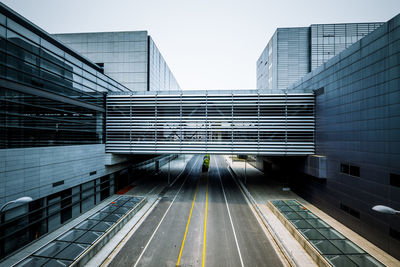 Low angle view of railroad tracks amidst buildings against clear sky