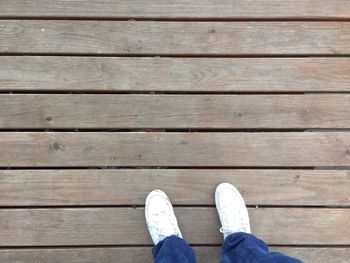 Low section of man standing on hardwood floor