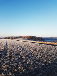 Scenic view of frozen lake against clear blue sky