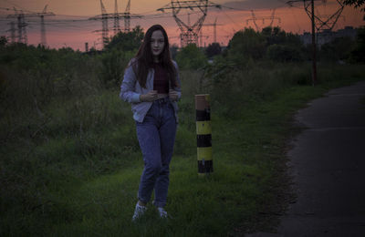 Full length of smiling young woman standing on field