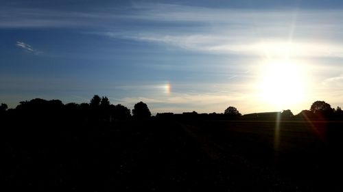 Silhouette field against sky during sunset