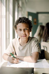 Portrait of male student studying in classroom