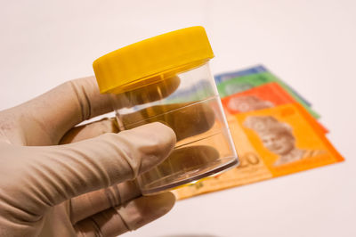 Close-up of hand holding food over white background