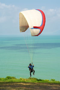 Rear view of person paragliding against sky