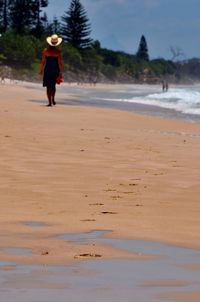 Rear view of woman running on beach