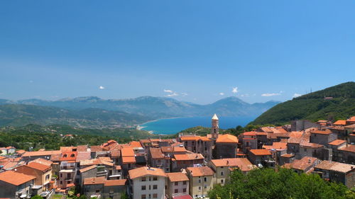 Houses in town against clear blue sky