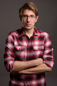 Portrait of man standing against black background