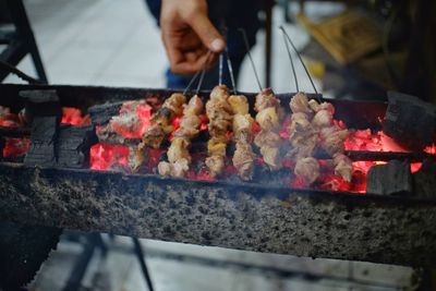 Person preparing food on barbecue grill