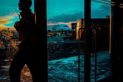 Man standing by swimming pool in city against sky