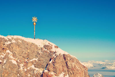 Summit cross on zugspitze mountain peak against clear sky