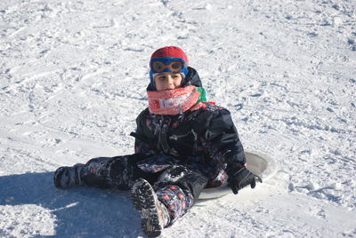 Boy tobogganing on snow