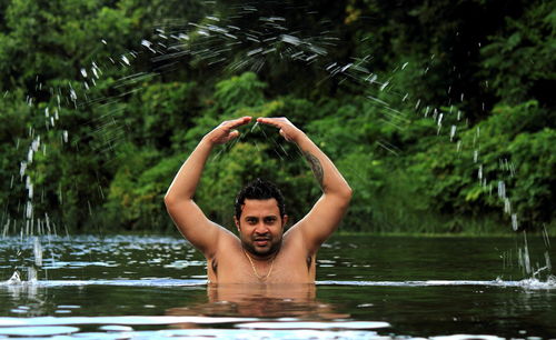 Portrait of man splashing water in lake
