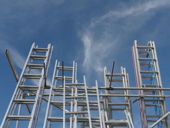 Low angle view of ladders against blue sky