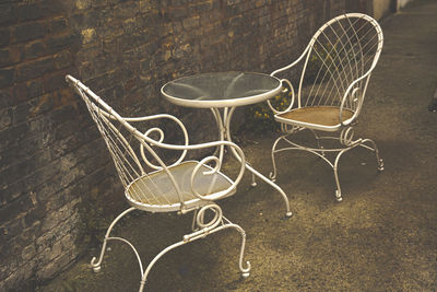 High angle view of empty chairs on table against wall