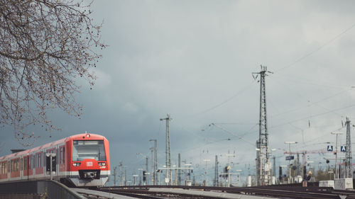 Train by railroad tracks against sky