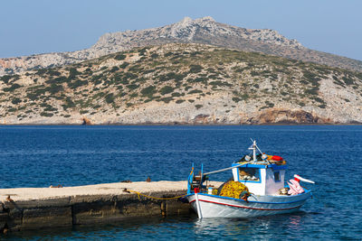 Pier and a traditional fishing boat in the harbour of fourni island.