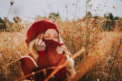 Portrait of woman wearing hat sitting on field