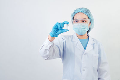 Portrait of teenage girl standing against white background