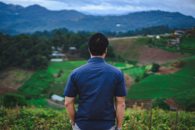 Rear view of man looking at field