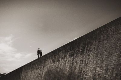 Low angle view of man standing against wall