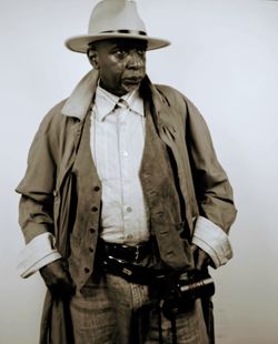 Portrait of man wearing hat standing against white background